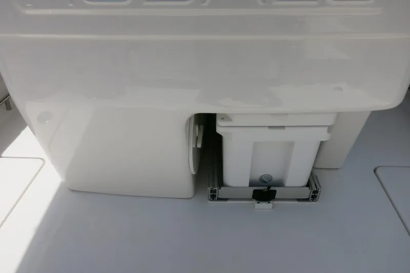 Slide: The Image of 2026 Robalo R270 Center Console storage compartment with white container. - 35