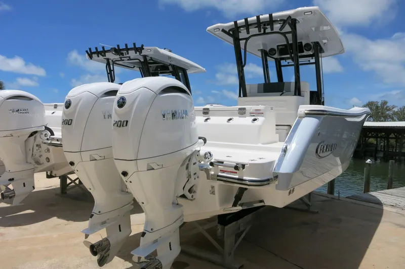 Slide: The Image of 2026 Robalo R270 Center Console boat with twin Yamaha engines docked outdoors. - 1