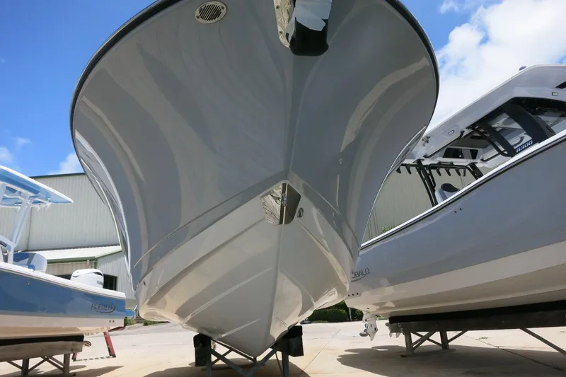 Slide: The Image of 2026 Robalo R270 Center Console boat, docked outdoors under a clear blue sky. - 4