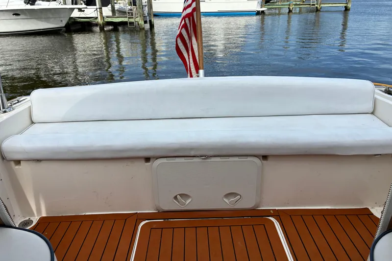 Slide: The Image of 2005 Marlow 375 boat interior with white seating and wooden deck. - 12