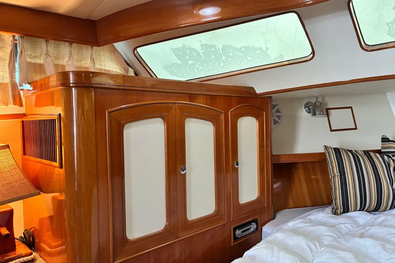 Slide: The Image of Luxurious cabin interior of a 2005 Marlow 375 yacht with wood paneling and cozy bedding. - 27