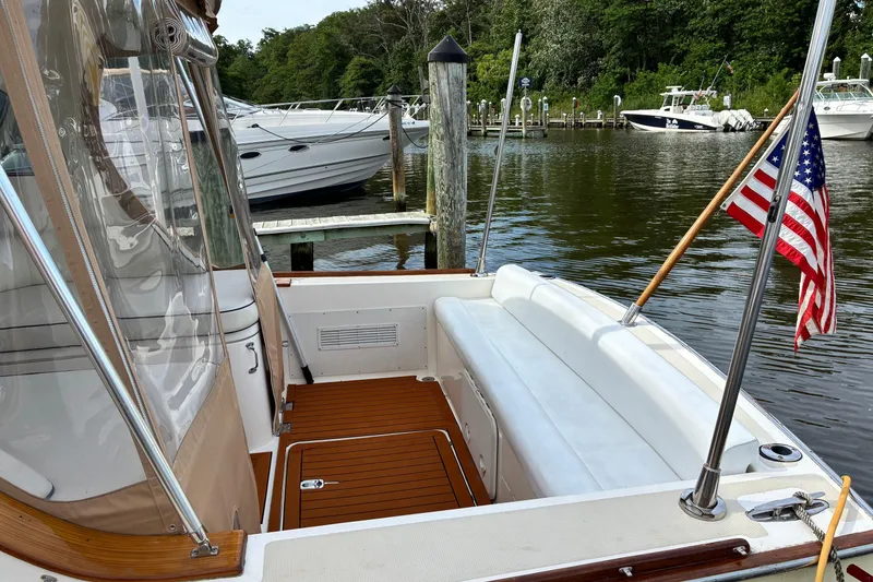 Slide: The Image of 2005 Marlow 375 boat with American flag, docked in a serene marina setting. - 3