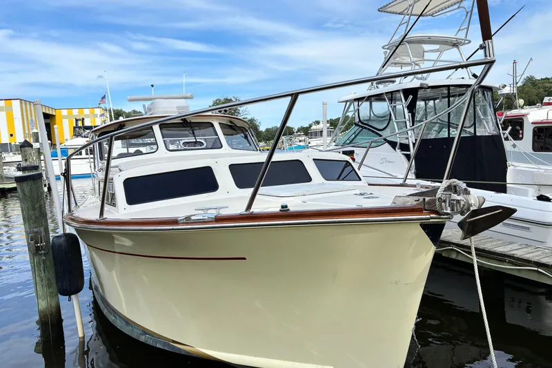 Slide: The Image of 2005 Marlow 375 boat docked at marina, featuring sleek design and polished wood accents. - 2