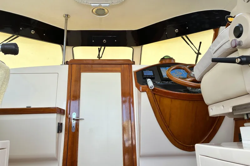 Slide: The Image of Interior view of a 2005 Marlow 375 yacht helm with wooden accents and navigation equipment. - 47