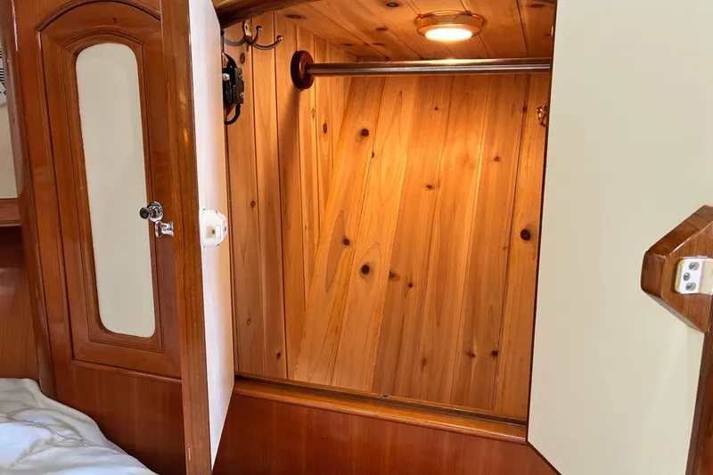 Slide: The Image of Wooden closet interior on a 2005 Marlow 375 yacht, featuring warm lighting and polished finish. - 41