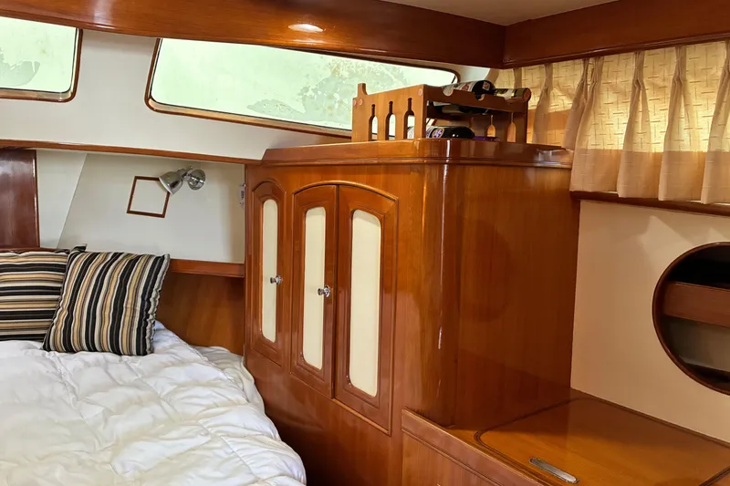 Slide: The Image of Cozy cabin interior of 2005 Marlow 375 yacht with wooden cabinetry and striped pillows. - 29