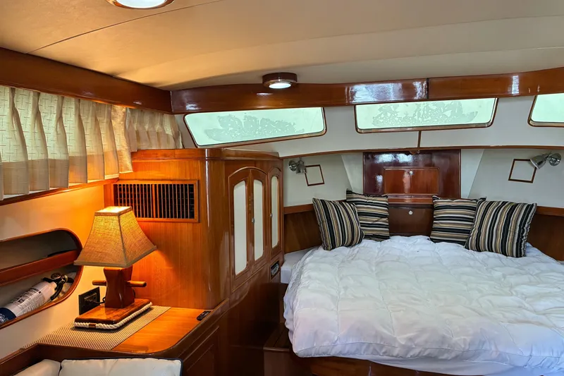 Slide: The Image of Luxurious cabin interior of a 2005 Marlow 375 yacht with cozy bedding and elegant wood finishes. - 30