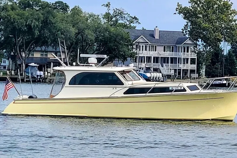 The Image of Yellow 2005 Marlow 375 boat on water near waterfront homes. - 0