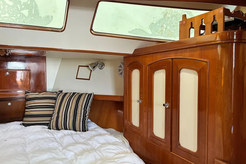 Slide: The Image of Cozy cabin interior of 2005 Marlow 375 yacht with wooden cabinetry and striped pillows. - 28