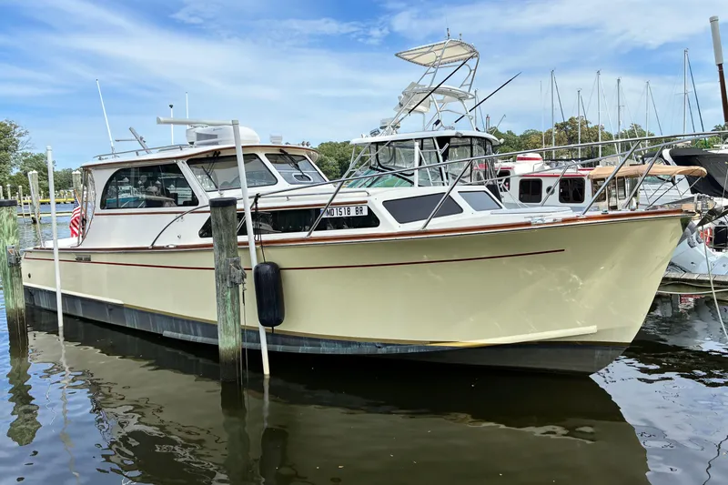 The Image of 2005 Marlow 375 boat docked in a marina, surrounded by other vessels. - 0