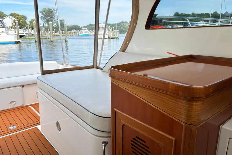 Slide: The Image of Interior of a 2005 Marlow 375 yacht with wooden cabinetry and cushioned seating by the water. - 16