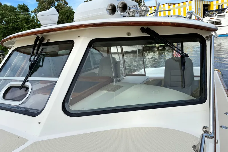 Slide: The Image of 2005 Marlow 375 boat with windshield wipers, docked near colorful building. - 6