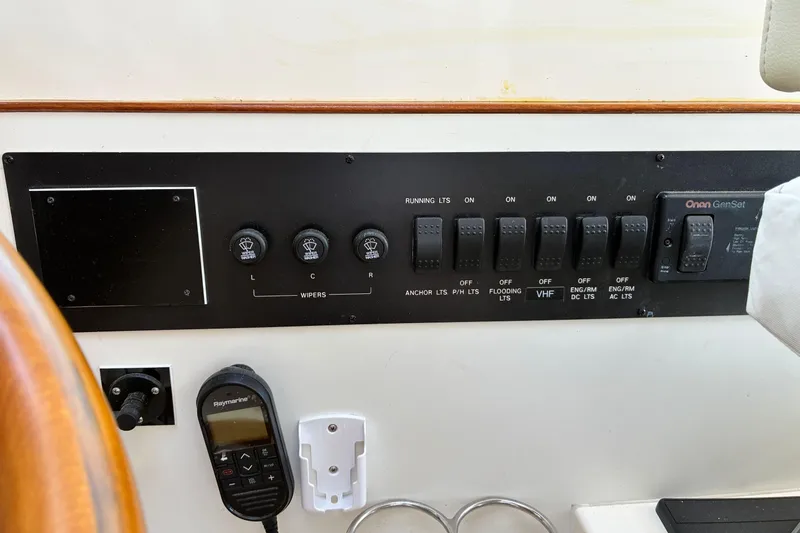 Slide: The Image of Control panel of a 2005 Marlow 375 boat with switches and a Raymarine device. - 24