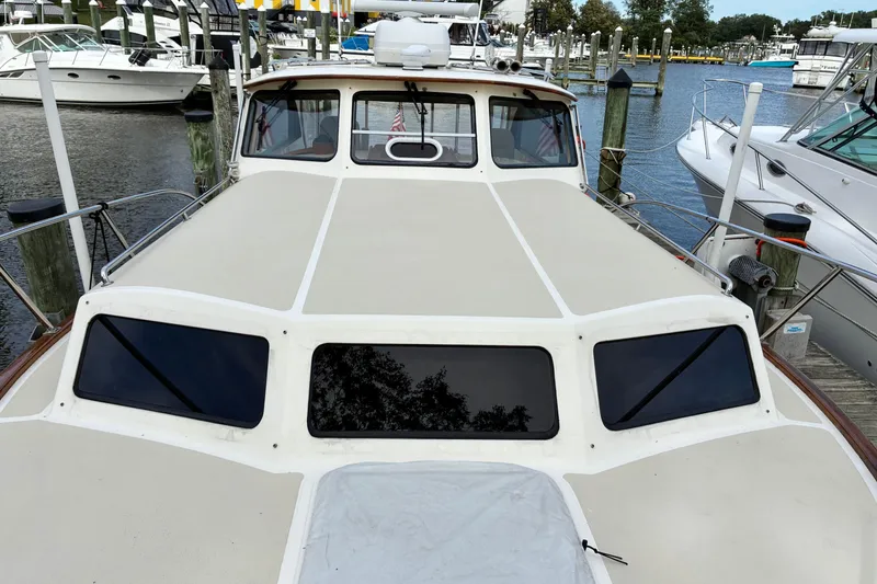 Slide: The Image of 2005 Marlow 375 yacht docked at marina, showcasing sleek design and spacious deck. - 8