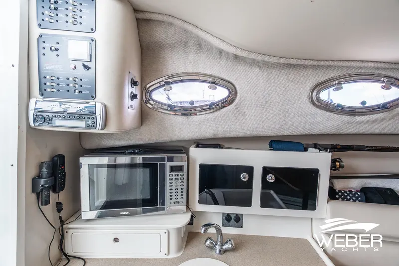 Slide: The Image of 2004 Hydra-Sports Vector 2800 WA cabin interior with microwave, control panel, and portholes. - 19