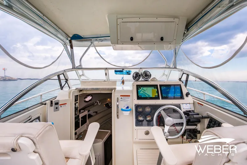 Slide: The Image of 2004 Hydra-Sports Vector 2800 WA boat cockpit with navigation screens and steering wheel. - 8