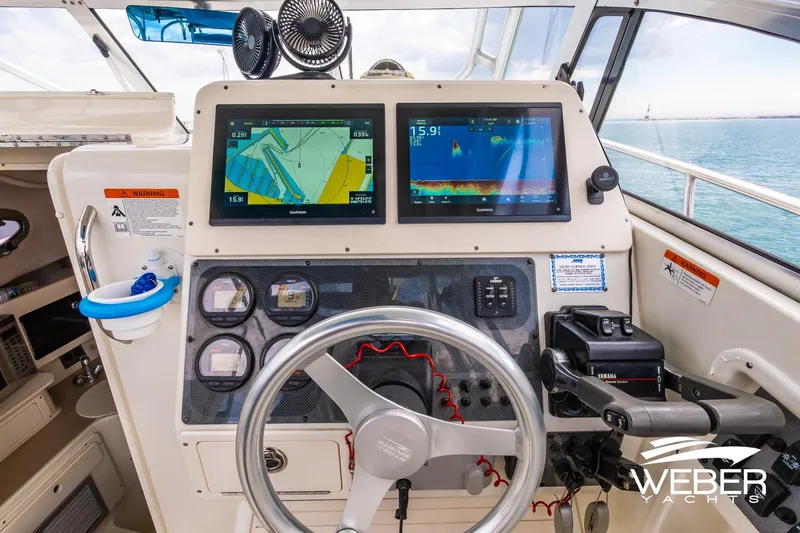 Slide: The Image of 2004 Hydra-Sports Vector 2800 WA helm with navigation screens and controls, ocean view. - 11