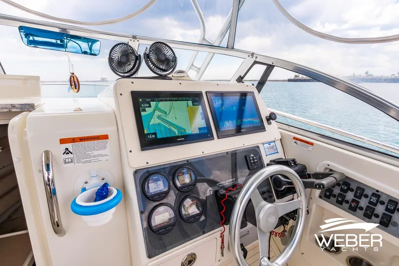 Slide: The Image of 2004 Hydra-Sports Vector 2800 WA boat cockpit with navigation screens and steering wheel. - 5