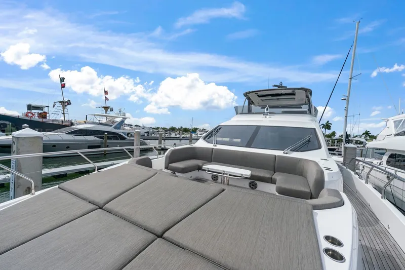 Slide: The Image of 2020 Azimut Fly 78 yacht docked, featuring spacious sunbathing area under clear blue sky. - 1