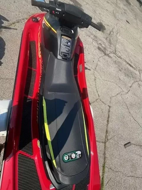 Slide: The Image of A red 2024 Waverunner EX DELUXE on concrete. The seat is black with yellow accents. - 6