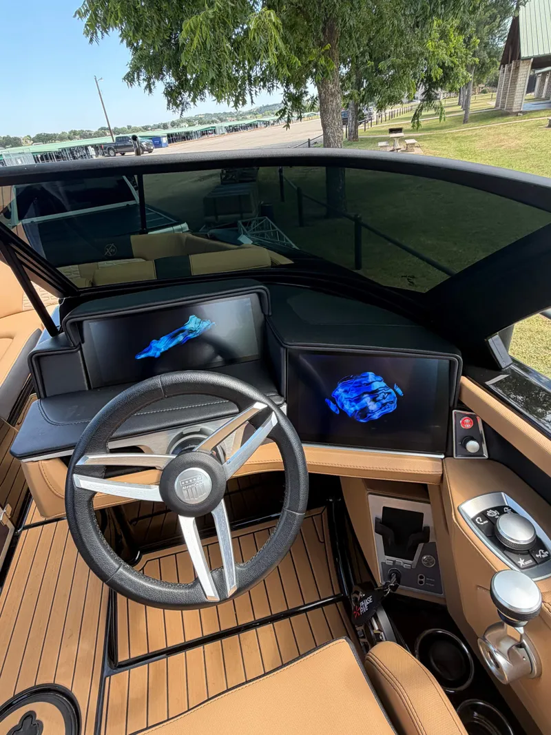 Slide: The Image of The cockpit of a 2025 MasterCraft X24 with a modern steering wheel and digital displays. - 16