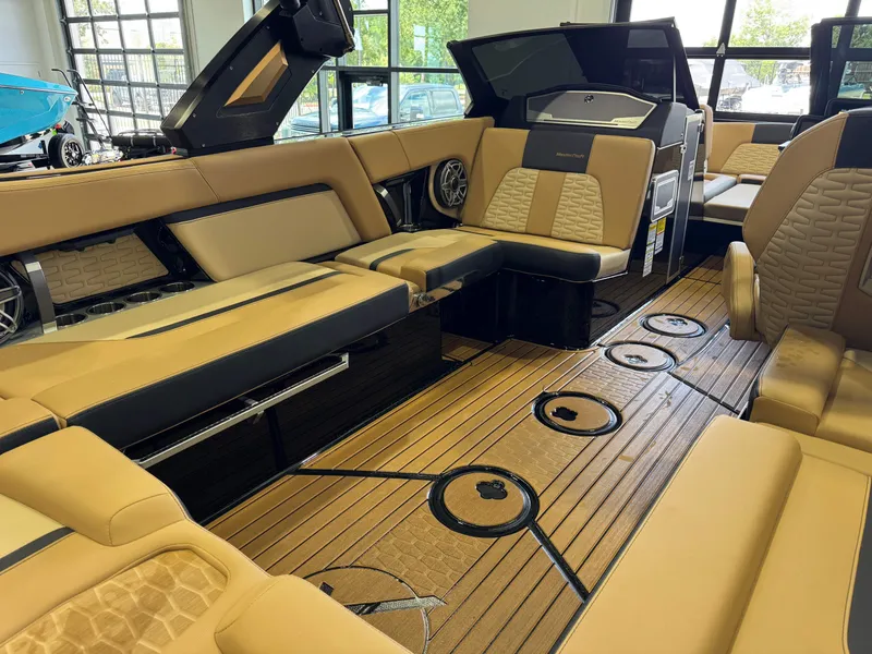 Slide: The Image of The image shows the luxurious interior of a MasterCraft X24 boat with beige upholstery and wood flooring. - 16