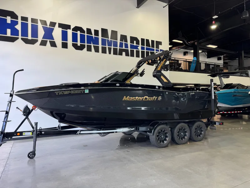 Slide: The Image of A black 2025 MasterCraft X24 boat on a trailer in a showroom. - 3