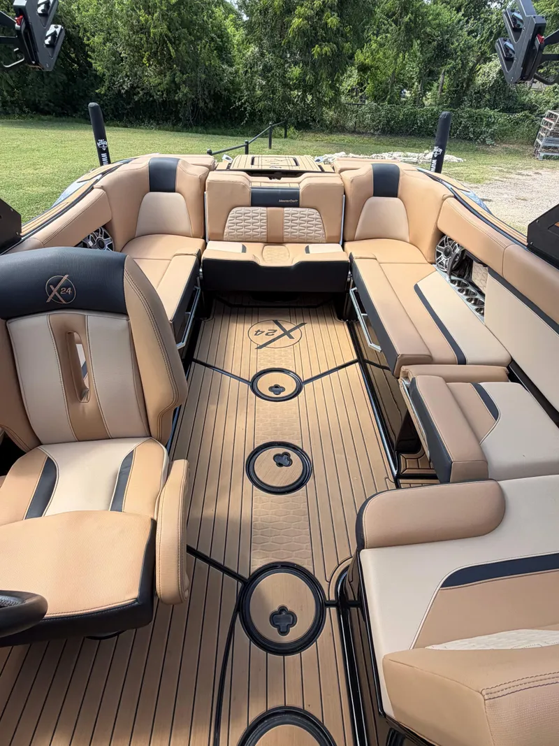 Slide: The Image of The image shows the interior of a 2025 MasterCraft X24 boat with luxurious seating and wood flooring. - 14