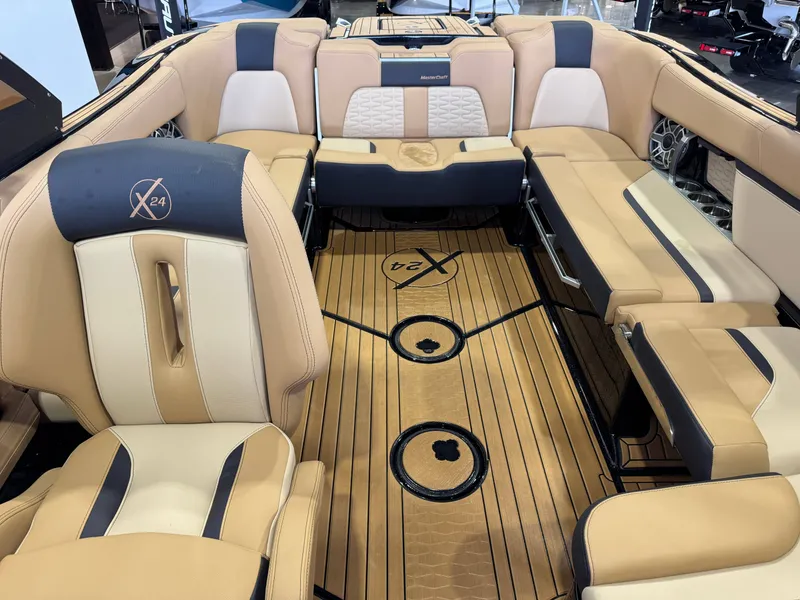 Slide: The Image of The image shows the luxurious interior of a MasterCraft X24 boat with beige and black seating. - 24