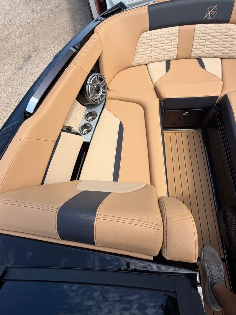 Slide: The Image of The image shows the luxurious interior of a MasterCraft X24 boat with elegant beige upholstery. - 13