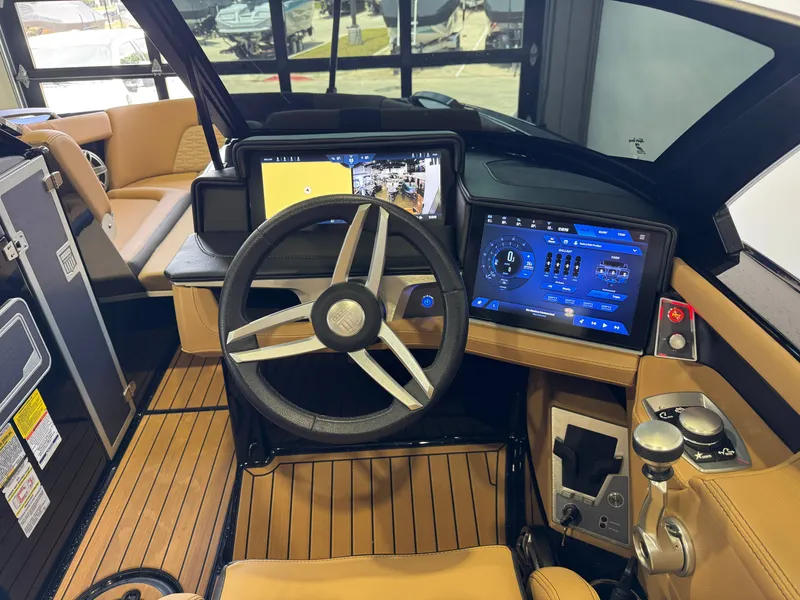Slide: The Image of The cockpit of the 2025 MasterCraft X24 features a modern steering wheel and digital displays. - 28