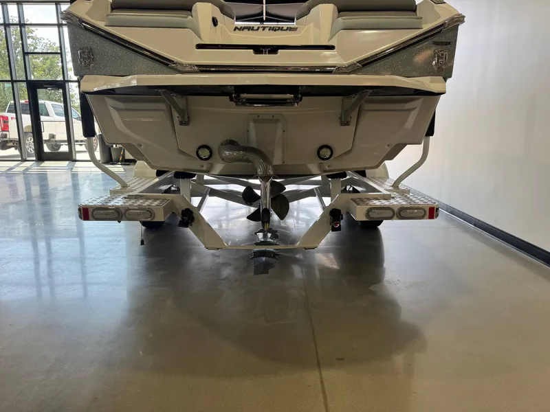 Slide: The Image of The image shows the rear of a 2022 Nautique Super Air Nautique G21 boat in a showroom. - 7