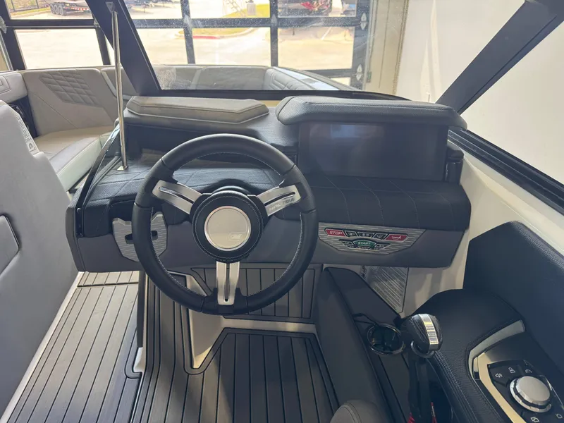 Slide: The Image of The image shows the cockpit of a 2022 Nautique Super Air Nautique G21 with a modern steering wheel and dashboard. - 26