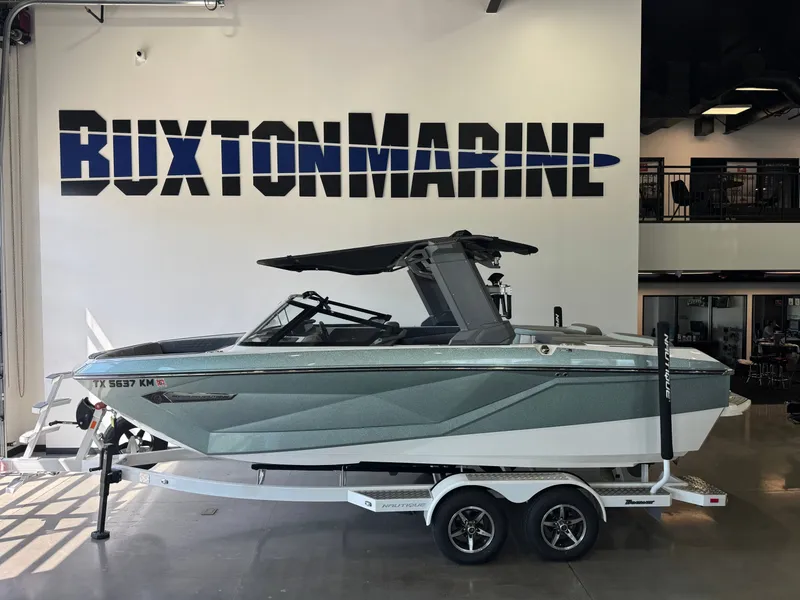 The Image of A 2022 Super Air Nautique G21 boat on a trailer in a showroom. - 1