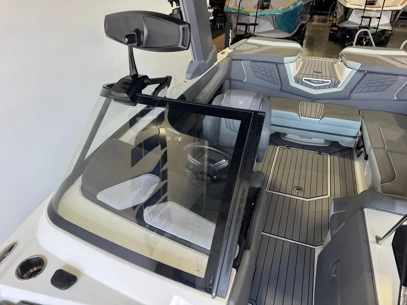 Slide: The Image of The image shows the cockpit of a 2022 Nautique Super Air Nautique G21 with gray upholstery. - 20