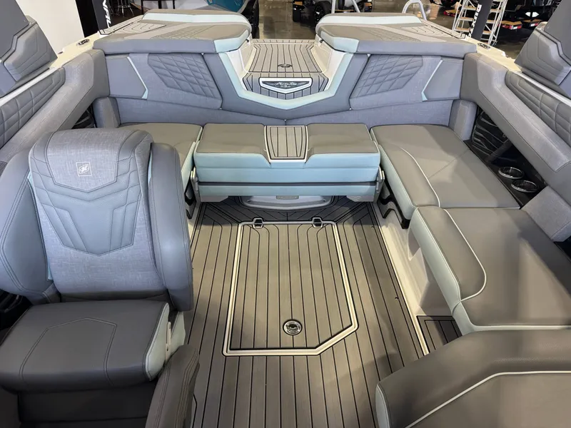 Slide: The Image of The image shows the interior of a 2022 Nautique Super Air Nautique G21 with gray upholstery. - 22