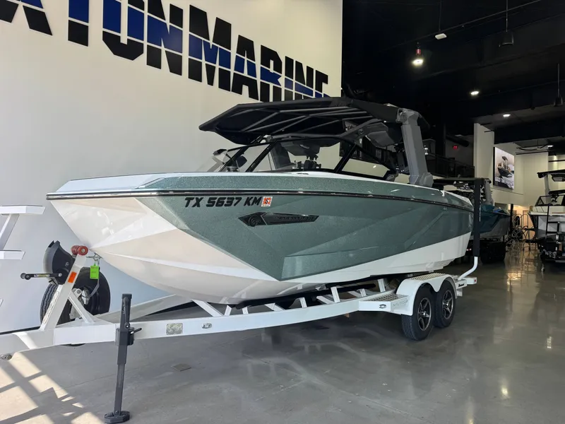 Slide: The Image of A 2022 Nautique Super Air Nautique G21 on a trailer in a showroom. - 2