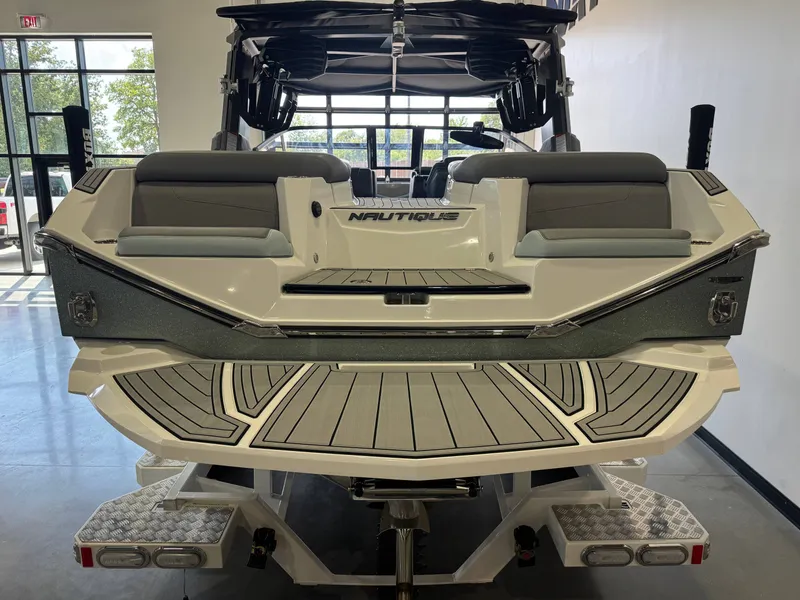 Slide: The Image of The image shows the rear of a 2022 Nautique Super Air Nautique G21 boat in a showroom. - 8