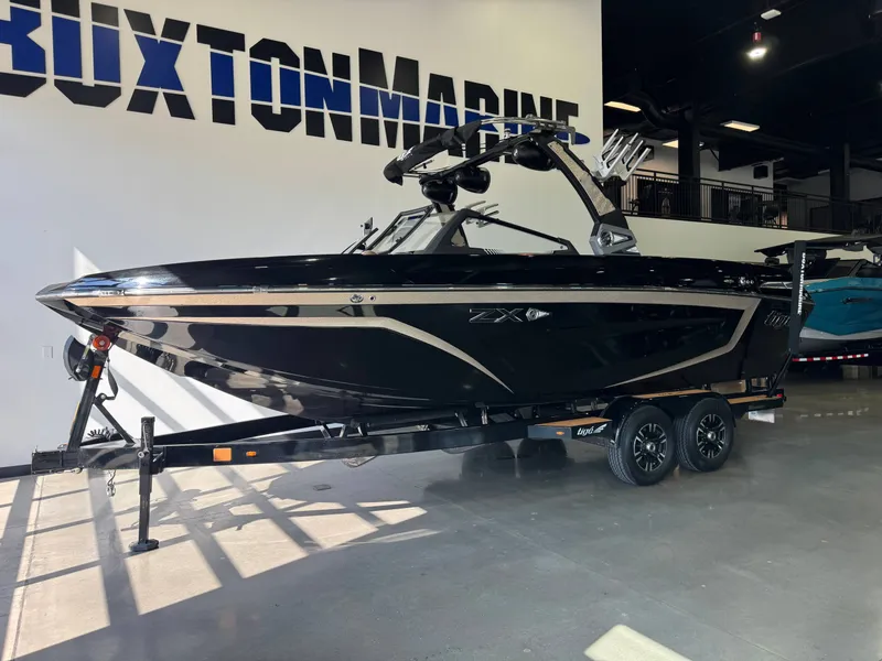 Slide: The Image of A black 2021 Tigé 25ZX boat sits on a trailer in a showroom. - 3