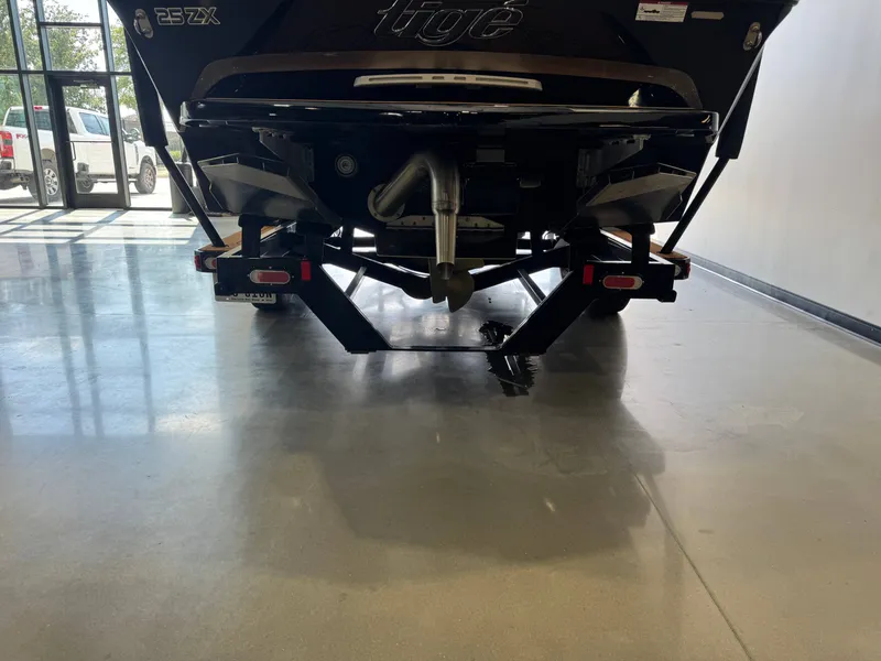 Slide: The Image of The image shows the rear of a 2021 Tigé 25ZX boat in a showroom. - 7