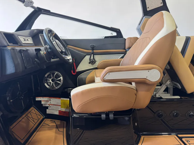 Slide: The Image of The image shows the interior of a 2021 Tigé 25ZX with a brown captain's chair and modern dashboard. - 22