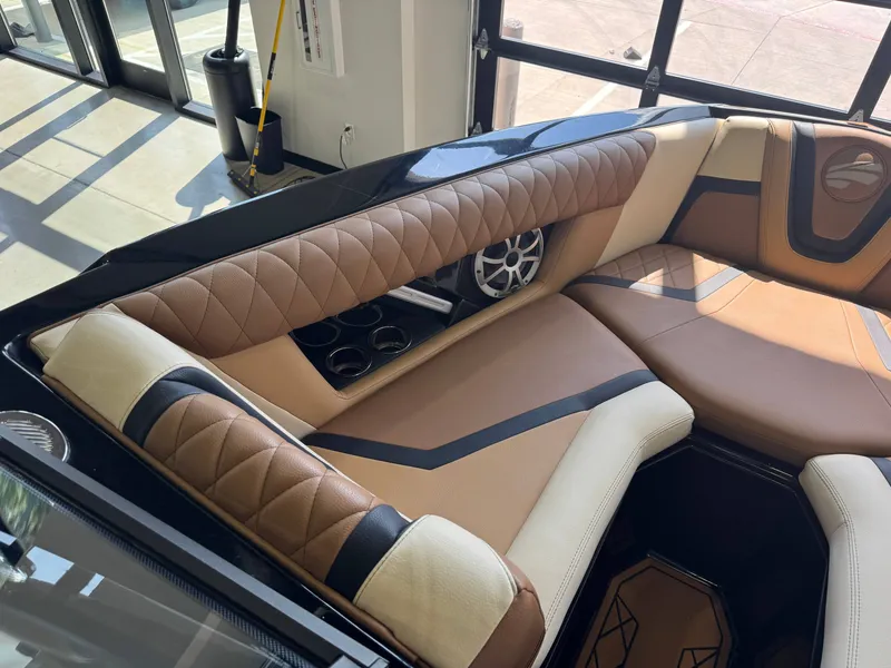 Slide: The Image of Interior of a 2021 Tigé 25ZX with sleek brown and cream upholstery and cup holders. - 18