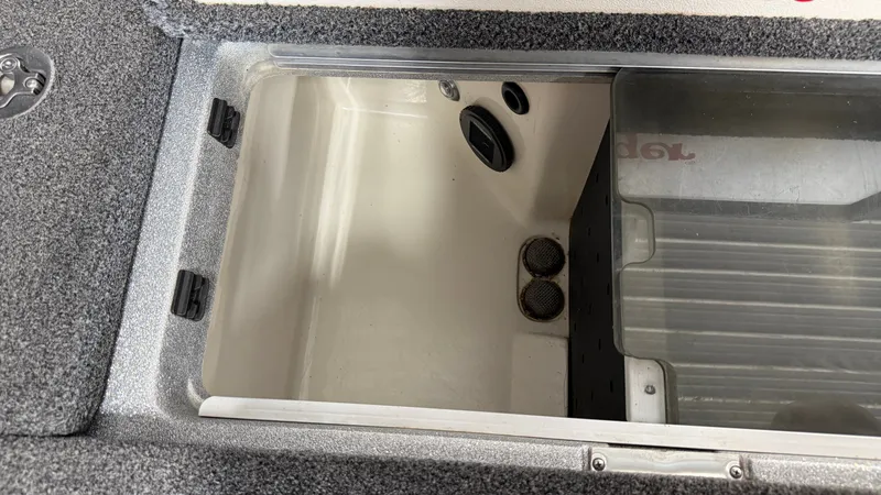 Slide: The Image of An open storage compartment on a 2015 Ranger Tugs Z520C boat, featuring gray carpeting. - 23