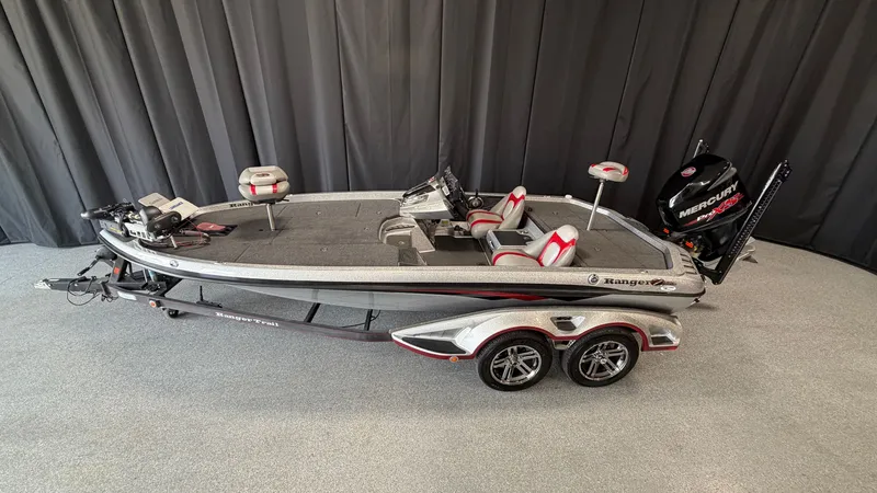 Slide: The Image of A 2015 Ranger Tugs Z520C on a trailer, featuring a gray and red design. - 1