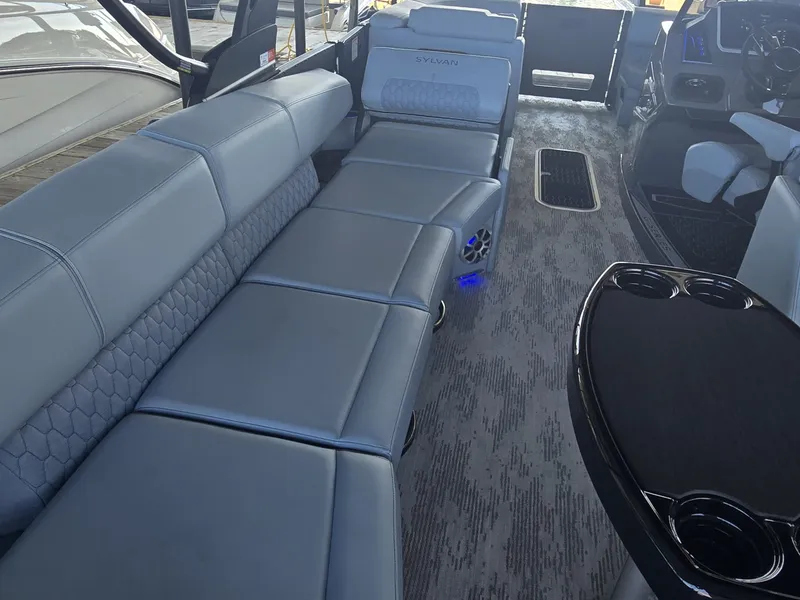 Slide: The Image of The image shows the interior of a 2027 Sylvan G-3 SLZ boat with luxurious blue seating. - 15