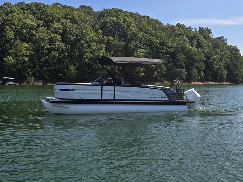 Slide: The Image of A modern pontoon boat by Sylvan, model G-3 SLZ, year 2027, cruising on a calm lake. - 0