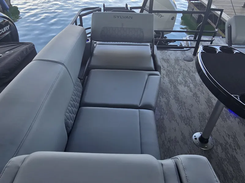 Slide: The Image of The image shows the interior of a Sylvan G-3 SLZ boat with gray upholstery and a table. - 12