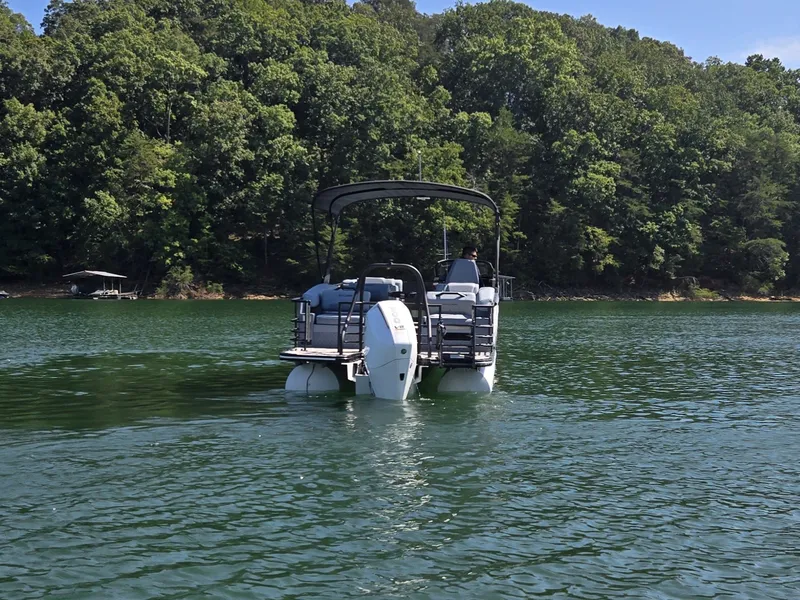 Slide: The Image of A 2027 Sylvan G-3 SLZ pontoon boat on a calm lake, surrounded by trees. - 39
