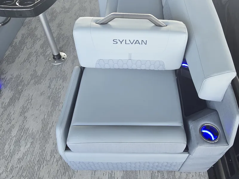 Slide: The Image of A sleek seating area with gray upholstery and blue cup holders on a Sylvan boat. - 10