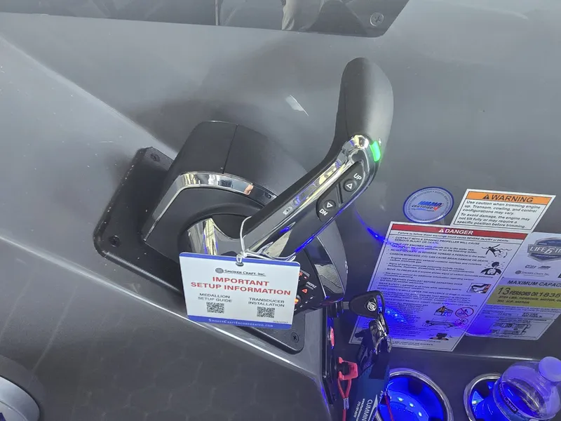Slide: The Image of Close-up of a boat throttle lever with an information tag and warning labels. - 27